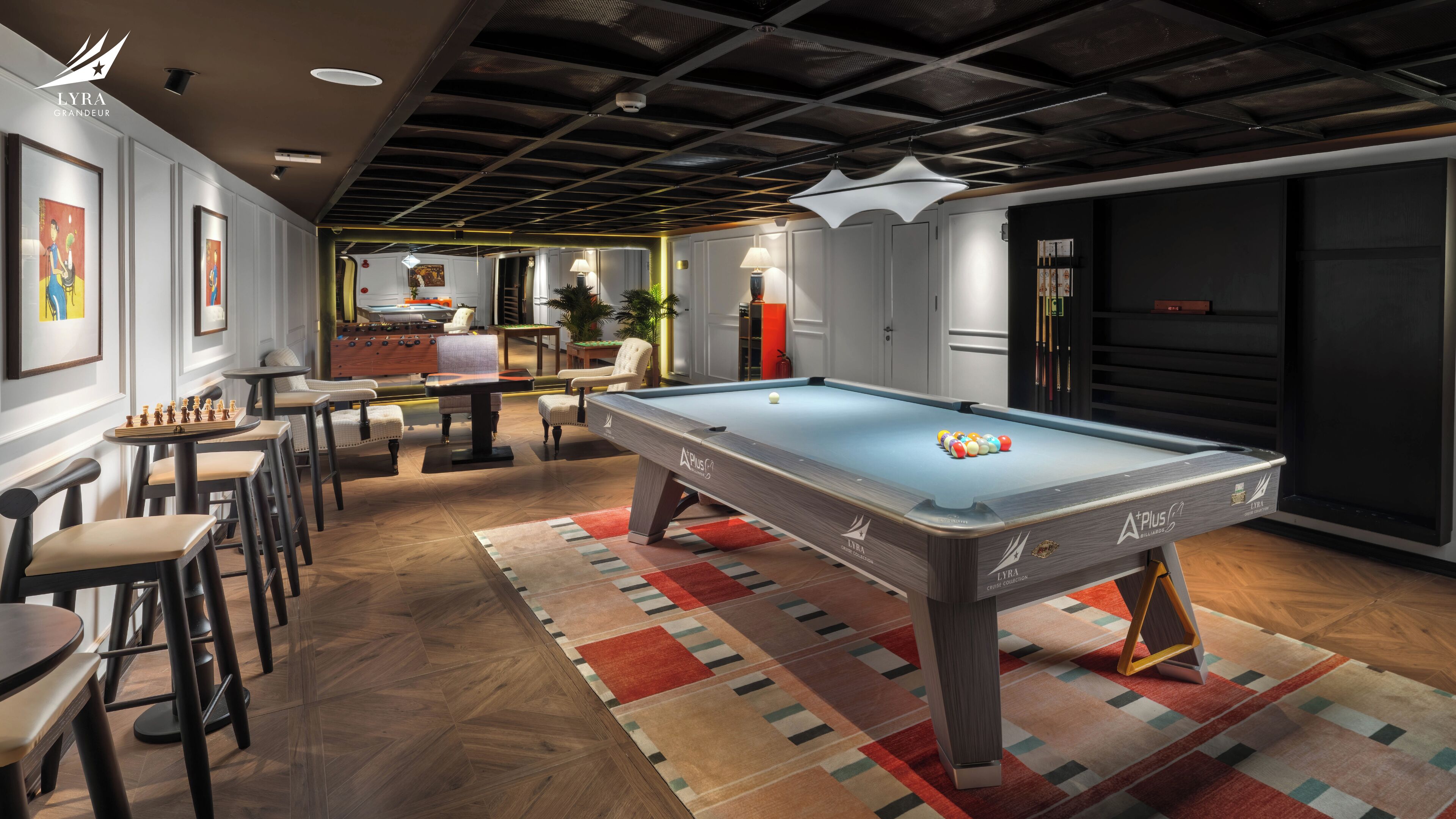 A billiards room with a pool table, chairs, and artwork on the walls.