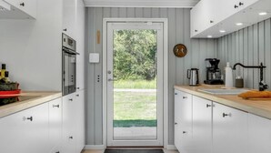 A modern kitchen with white cabinets, a built-in oven, and a coffee maker. - "Quiana" - 2km from the sea by Interhome (Pandrup)