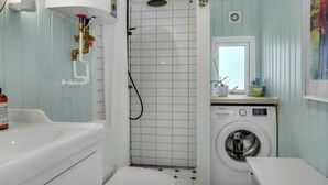 A bathroom with a bathtub, toilet, shower, and washing machine. - "Quiana" - 2km from the sea by Interhome (Pandrup)