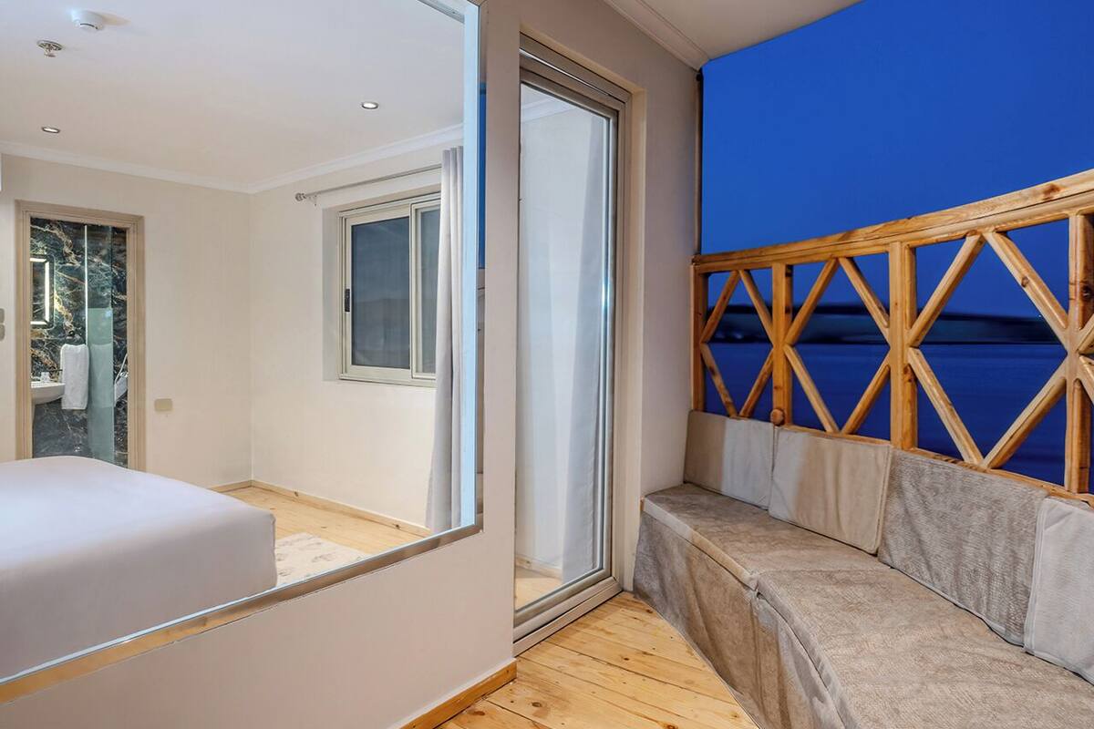 Un dormitorio con una cama grande, una ventana y vistas al mar.