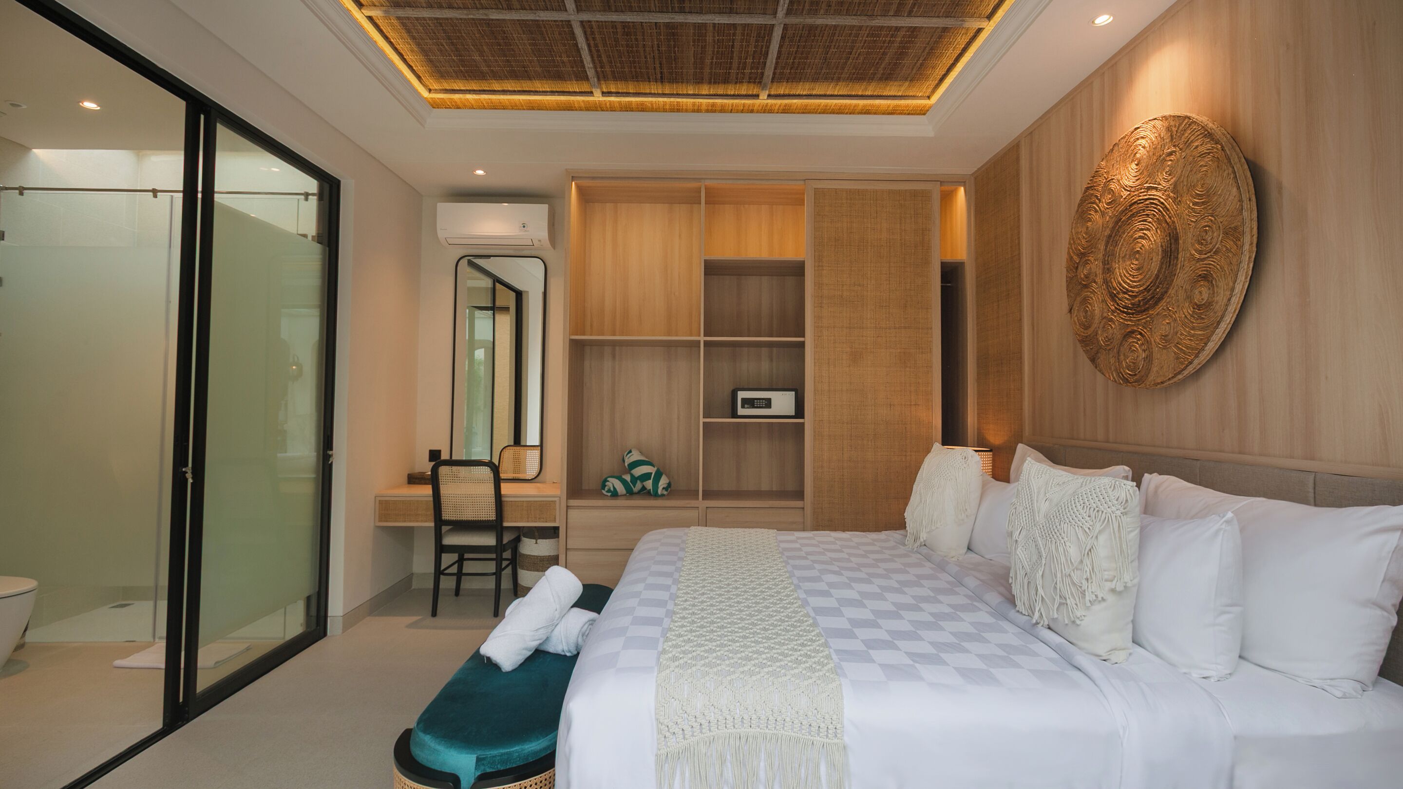 Une chambre d’hôtel moderne dotée d’un grand lit, d’un bureau avec une chaise, d’un dressing et d’un grand miroir.
