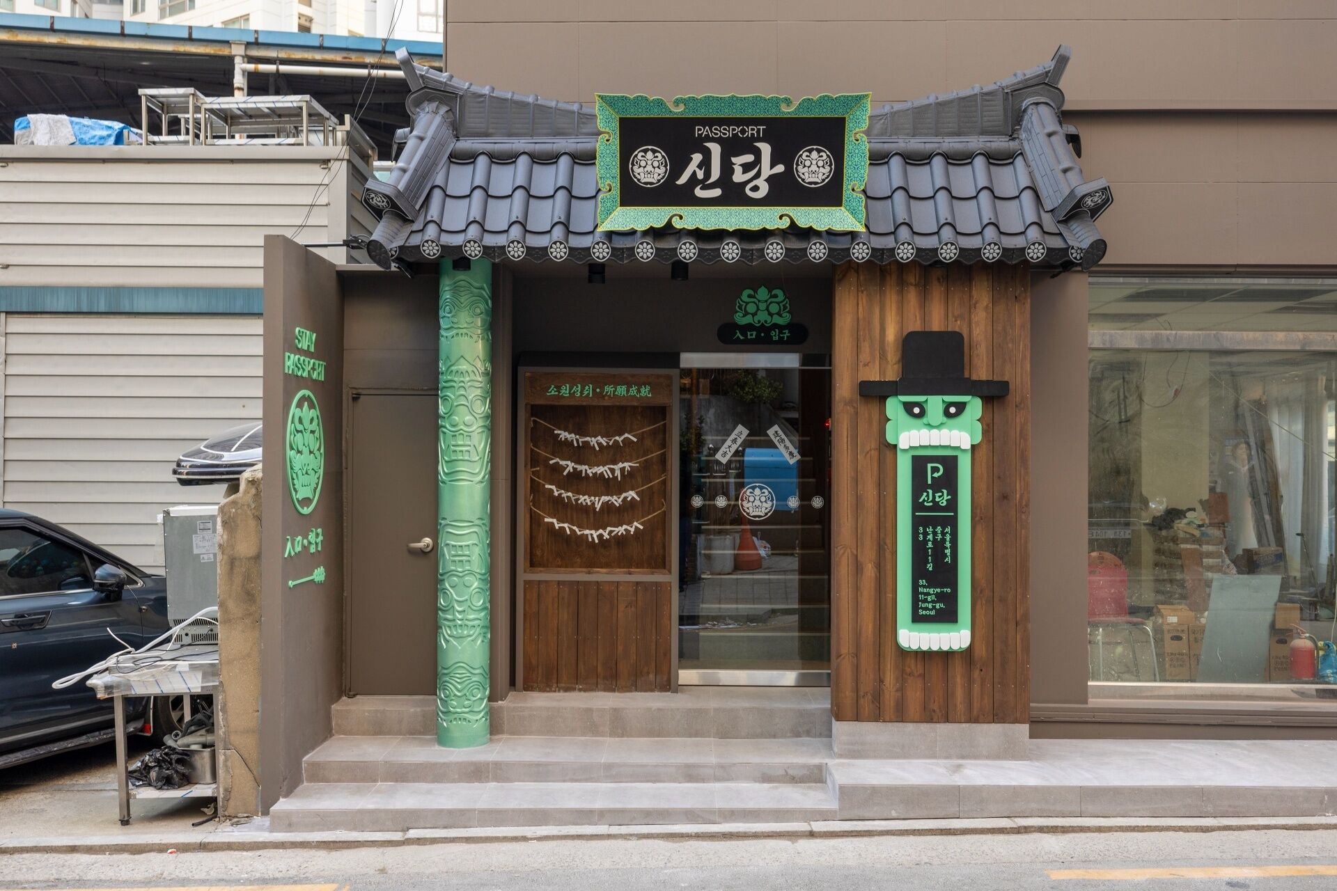 A traditional Korean entrance with a sign reading "Passport" and a green decorative pillar.