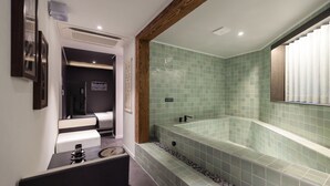 Un baño moderno con una bañera grande, un lavabo y un espejo.