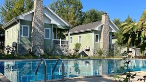 A two-story house with a stone chimney, a swimming pool with a stone deck, and a lush green landscape. - Rahat  (Khachmaz)