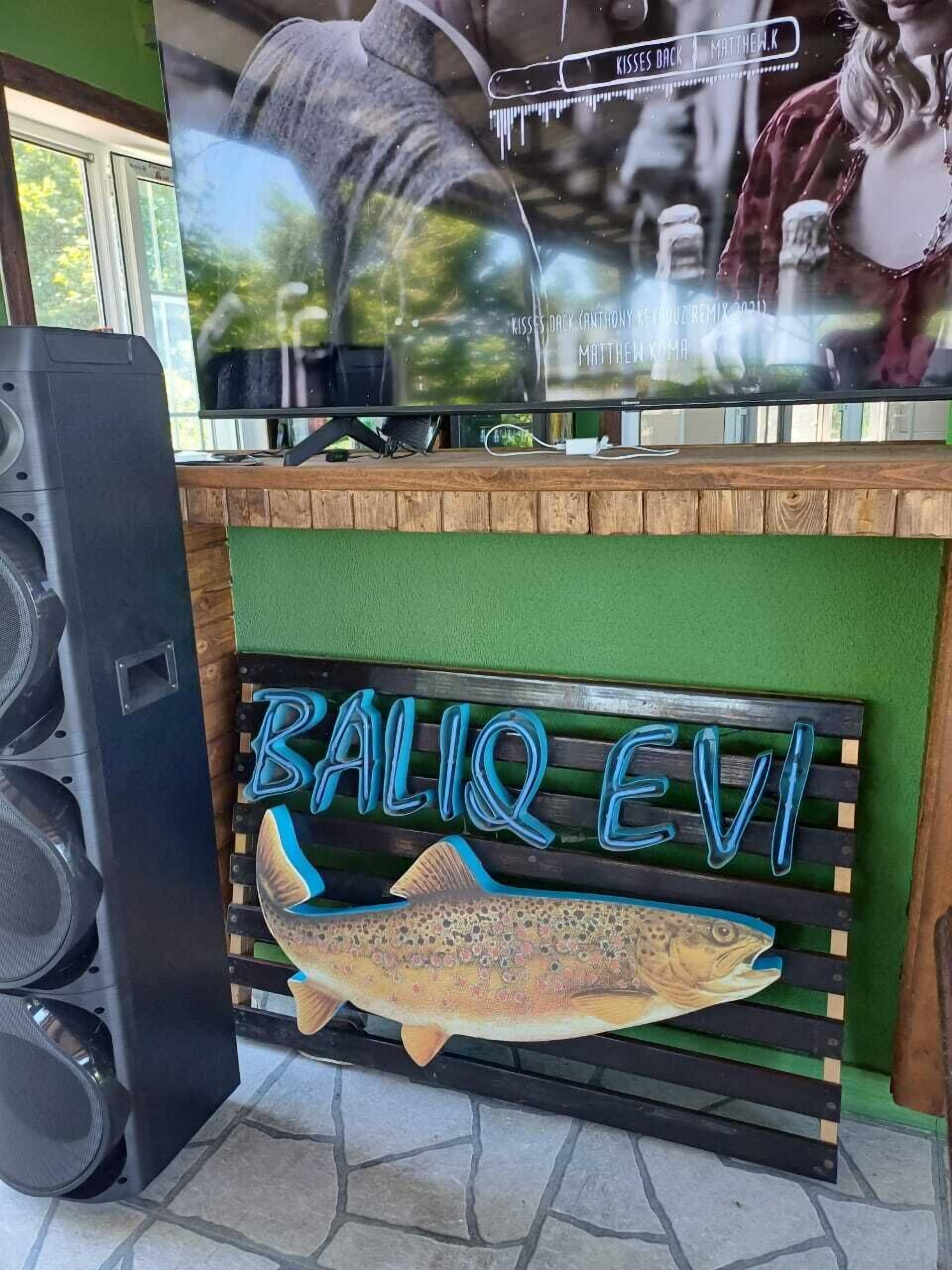 Uma mesa de recepção com uma placa em formato de peixe que diz 'BALIQ EVI'.