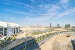 A modern building with a curved facade, a wide road with multiple lanes, and a clear blue sky. - Zapbed House - SP 803 (Dubai)