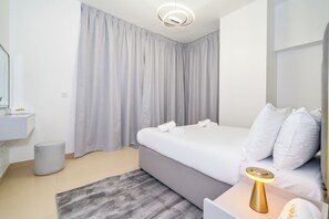 A modern hotel room with a bed, bedside table, lamp, and a bathroom with a mirror and sink. - Zapbed House - SP 803 (Dubai)