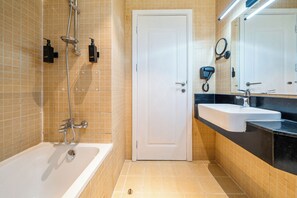 A bathroom with a bathtub, a sink, a mirror, and a door. - Zapbed House - SP 803 (Dubai)