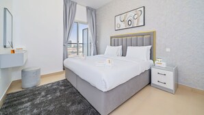 A modern bedroom with a large bed, a bedside table, a nightstand, a window with curtains, a wall-mounted artwork, and a small round stool. - Zapbed House - SP 803 (Dubai)