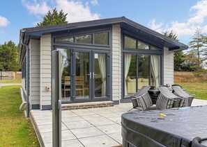 A modern house with a patio, sliding glass doors, and outdoor furniture. - 3 bedroom accommodation in Faringdon (Faringdon)