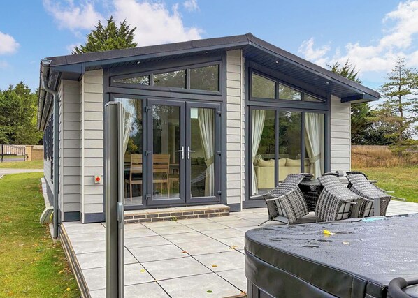 A modern house with a patio, sliding glass doors, and outdoor furniture.