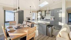 A modern kitchen with a central island, stainless steel appliances, and pendant lighting. - 3 bedroom accommodation in Faringdon (Faringdon)