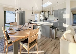 A modern kitchen with a central island, stainless steel appliances, and pendant lighting.