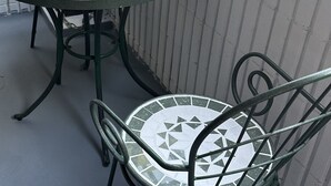 A round table with a mosaic tile design and metal chairs with matching patterns. - 2 min walk from Hanazonomachi station Japanese-style room with mini-kitchen with private bathroom Excellent access [ 203]. (大阪市)