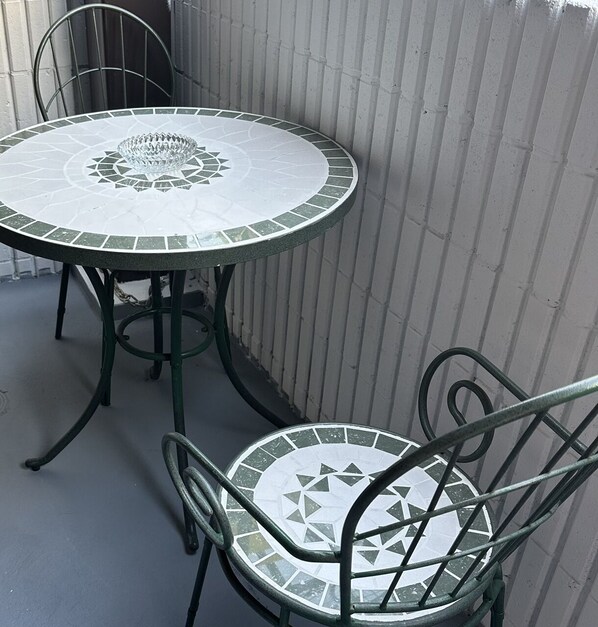 Enjoy meals al fresco at this charming outdoor dining area with a mosaic tile table and matching chairs.