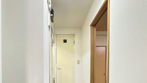 A narrow hallway with a wooden floor leading to a room with a sliding door. - 2 min walk from Hanazonomachi station Japanese-style room with mini-kitchen with private bathroom Excellent access [ 203]. (大阪市)