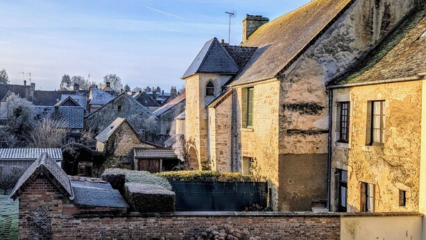 A historic stone building with a steeply pitched roof, a small attached structure, and a brick wall with a gate. - Enjoy a cozy setting with a stunning view of the majestic Sées Cathedral. (Sées)