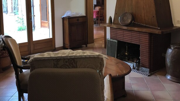 Un saló acollidor amb una llar de foc, un penjador de cristall i una zona de menjador.