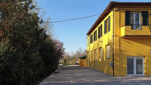 A yellow building with a balcony, a door, and a window. - Room-charming Guest Room in Frassino wit (Castel San Pietro Terme)