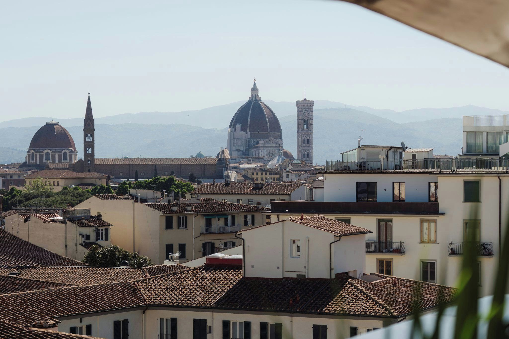 Une vue panoramique sur une ville, avec son architecture historique, notamment des bâtiments à coupole et un clocher, prise depuis un point de vue élevé.