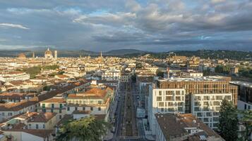 Un paisaje urbano con arquitectura histórica, una cúpula destacada y una calle central.
