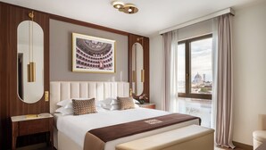 A modern hotel room with a large bed, a wooden headboard, a large mirror, a nightstand, and a view of the city. - Teatro Luxury Apartments Firenze - Starhotels Collezione (Florence)