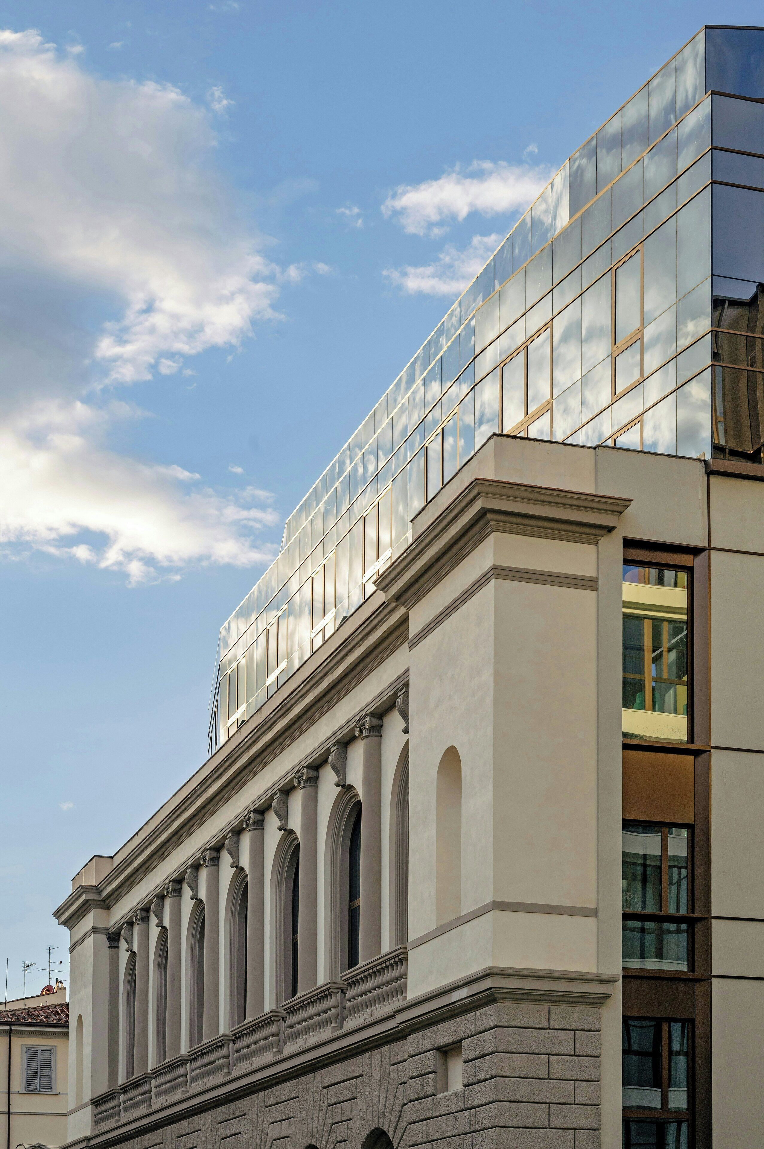 A modern building with a glass facade and classical architectural elements.