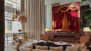 A modern living room with a curved sofa, two armchairs, a fireplace, and a large TV screen. - Teatro Luxury Apartments Firenze - Starhotels Collezione (Florence)