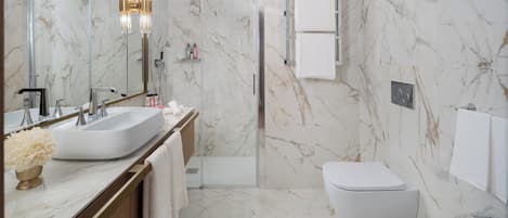 A modern bathroom with a large sink, a toilet, and a bidet.