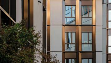 En byggnad med flera våningar och en modern arkitektonisk design, med stora fönster och en symmetrisk fasad.