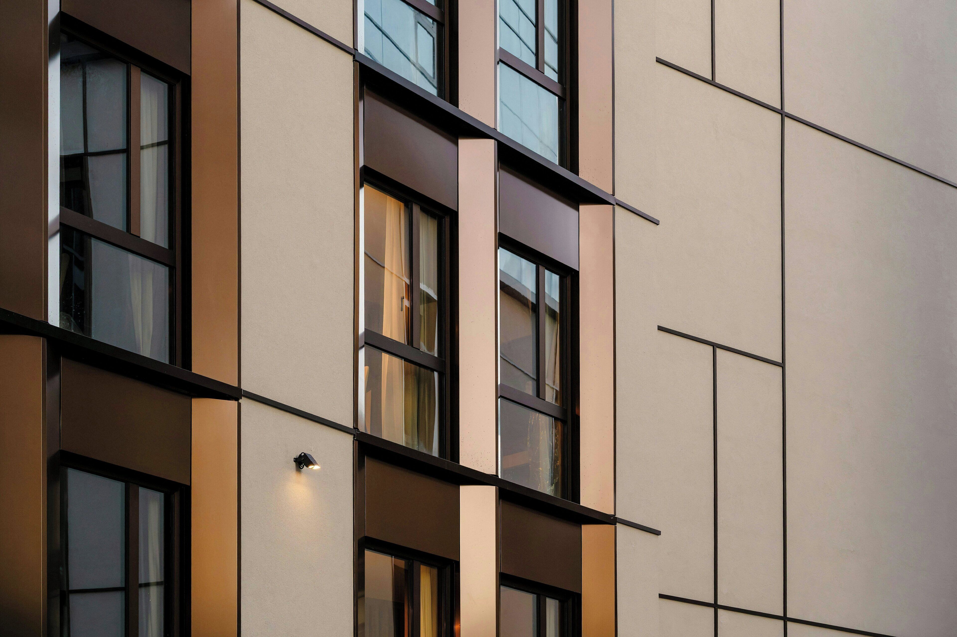 A modern building facade with multiple windows, a clean design, and a flat roof.
