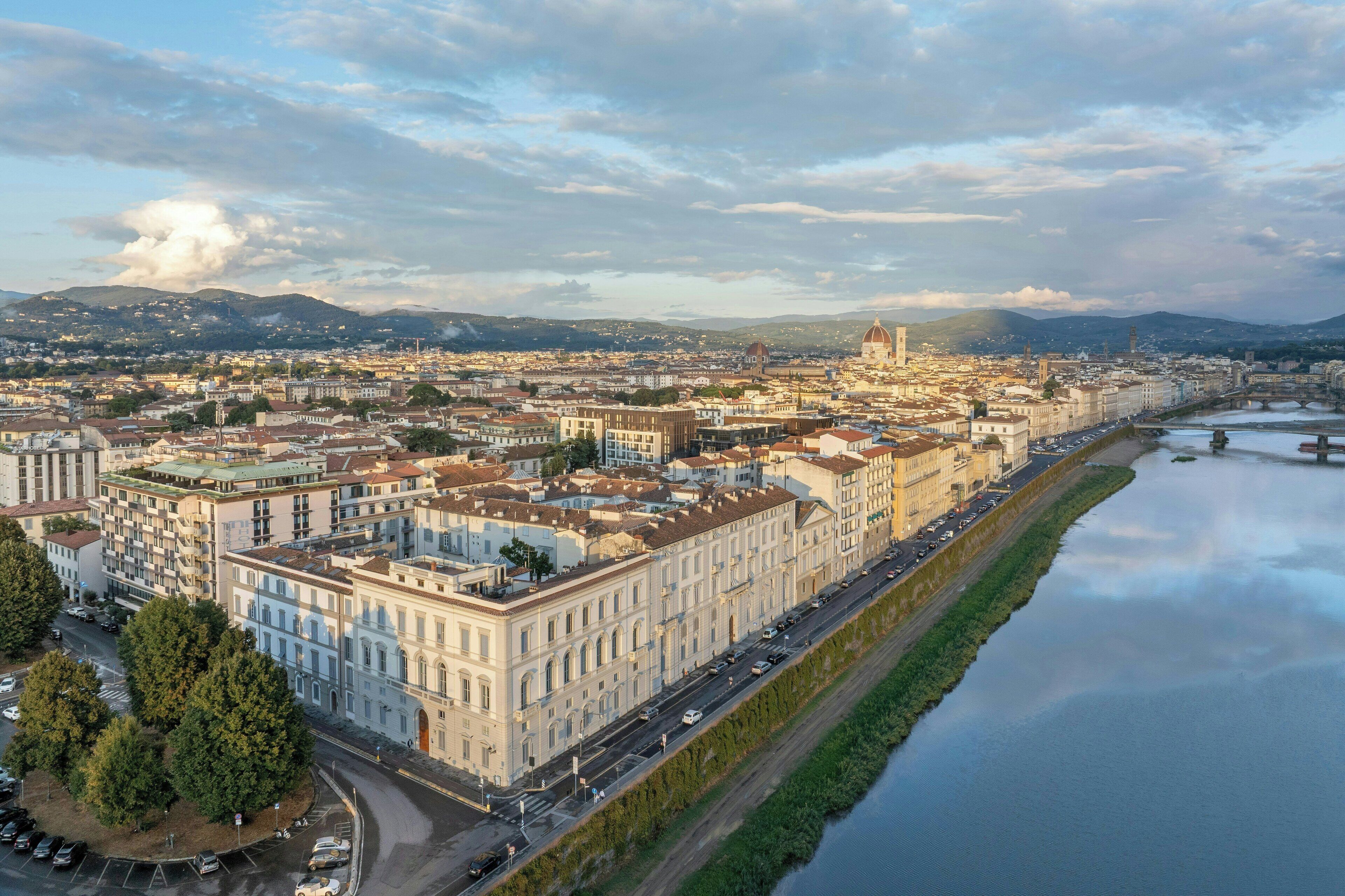 A cityscape with a river, historic buildings, and a prominent dome structure.