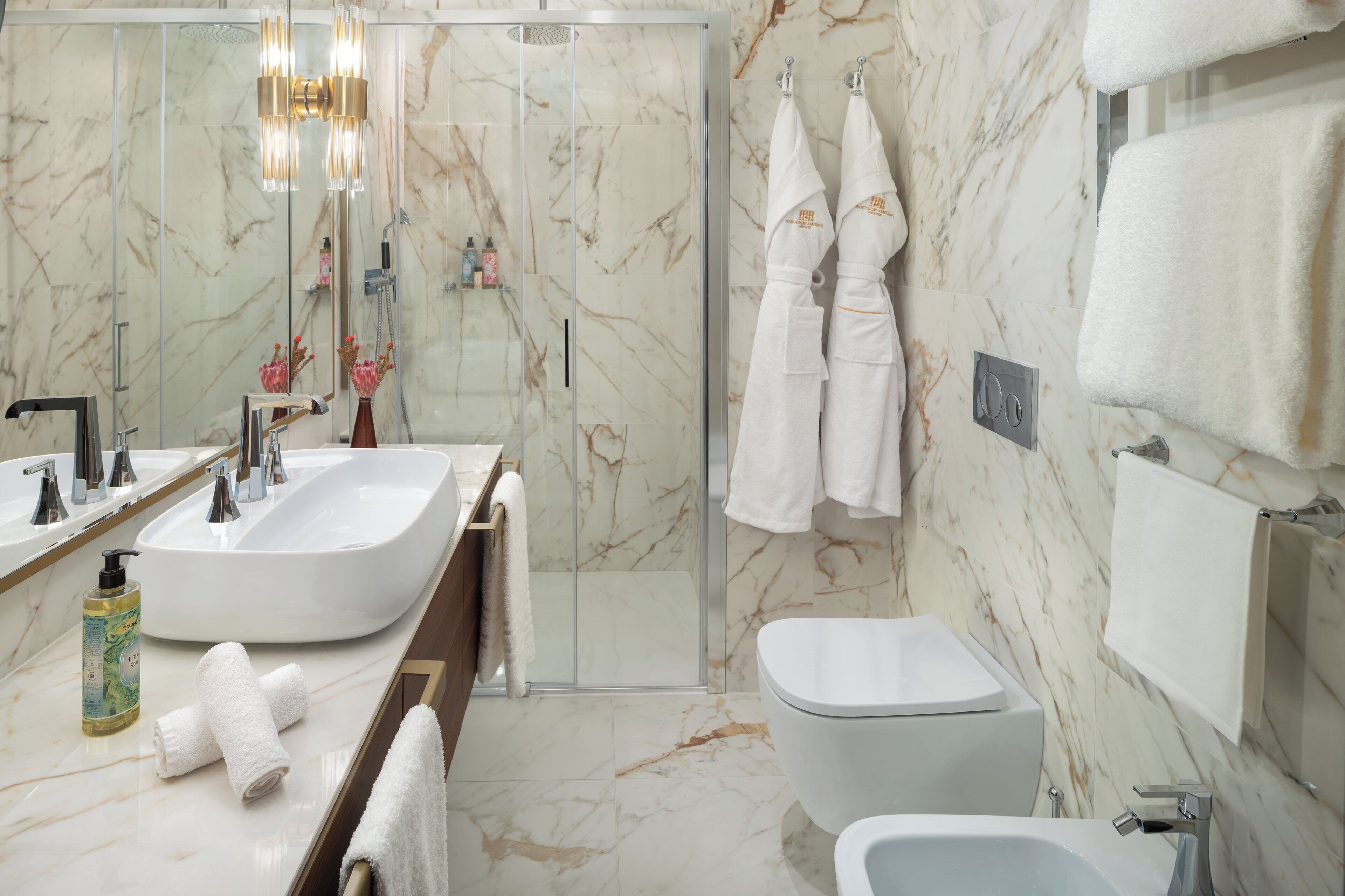 A modern bathroom with a large sink, a toilet, and a shower area.