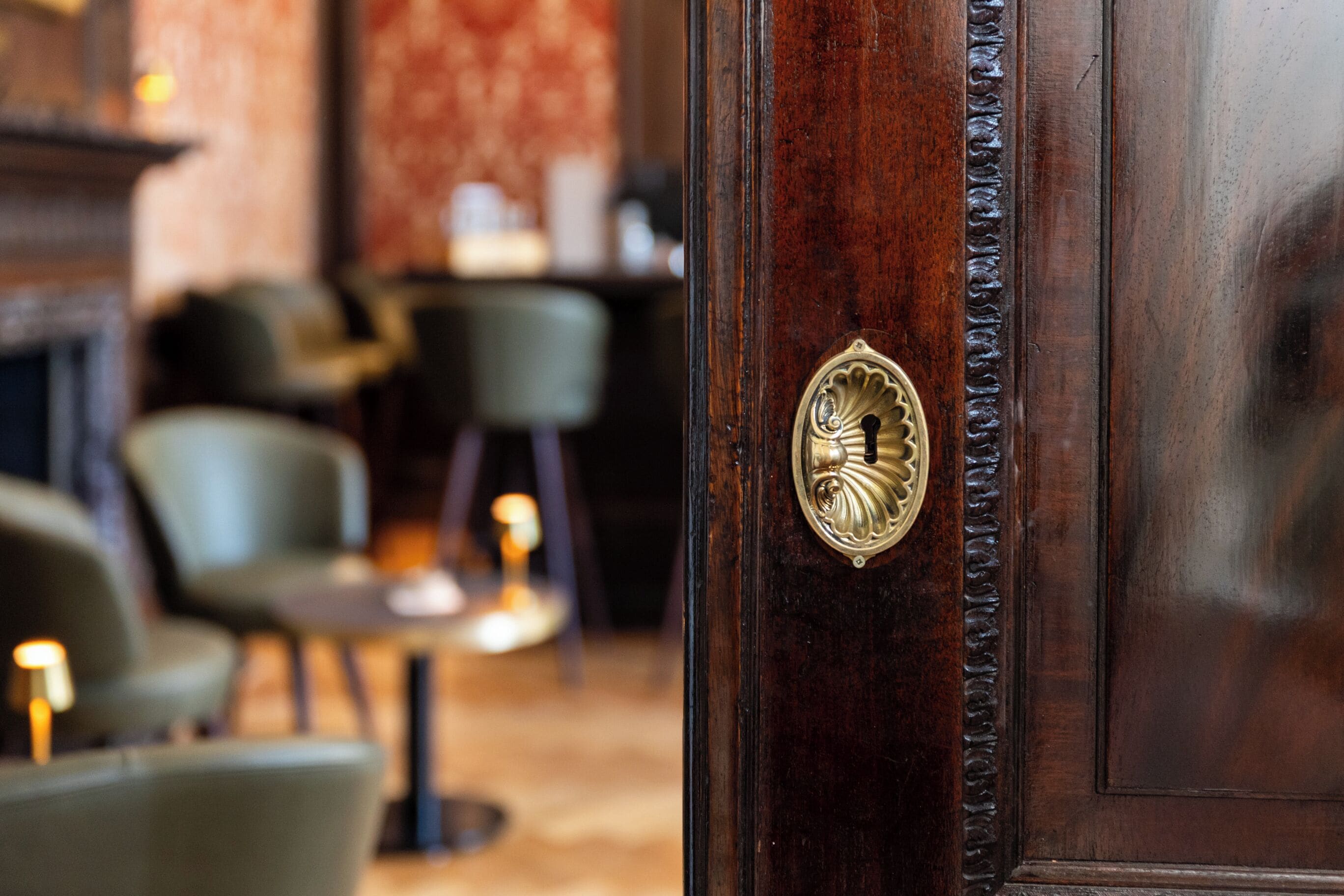 A wooden door with a brass handle and a decorative panel.