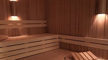 A sauna with wooden benches and wall-mounted lights.