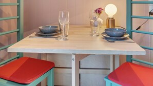 Une table dressée avec deux bols, deux verres à vin et un chandelier avec une bougie allumée.