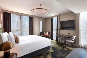 Relax in comfort with a large bed, seating area, and flat-screen TV.