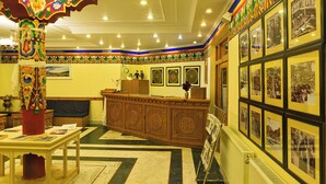Un interior tradicional con una recepción, fotografías enmarcadas en la pared y un pilar decorativo.