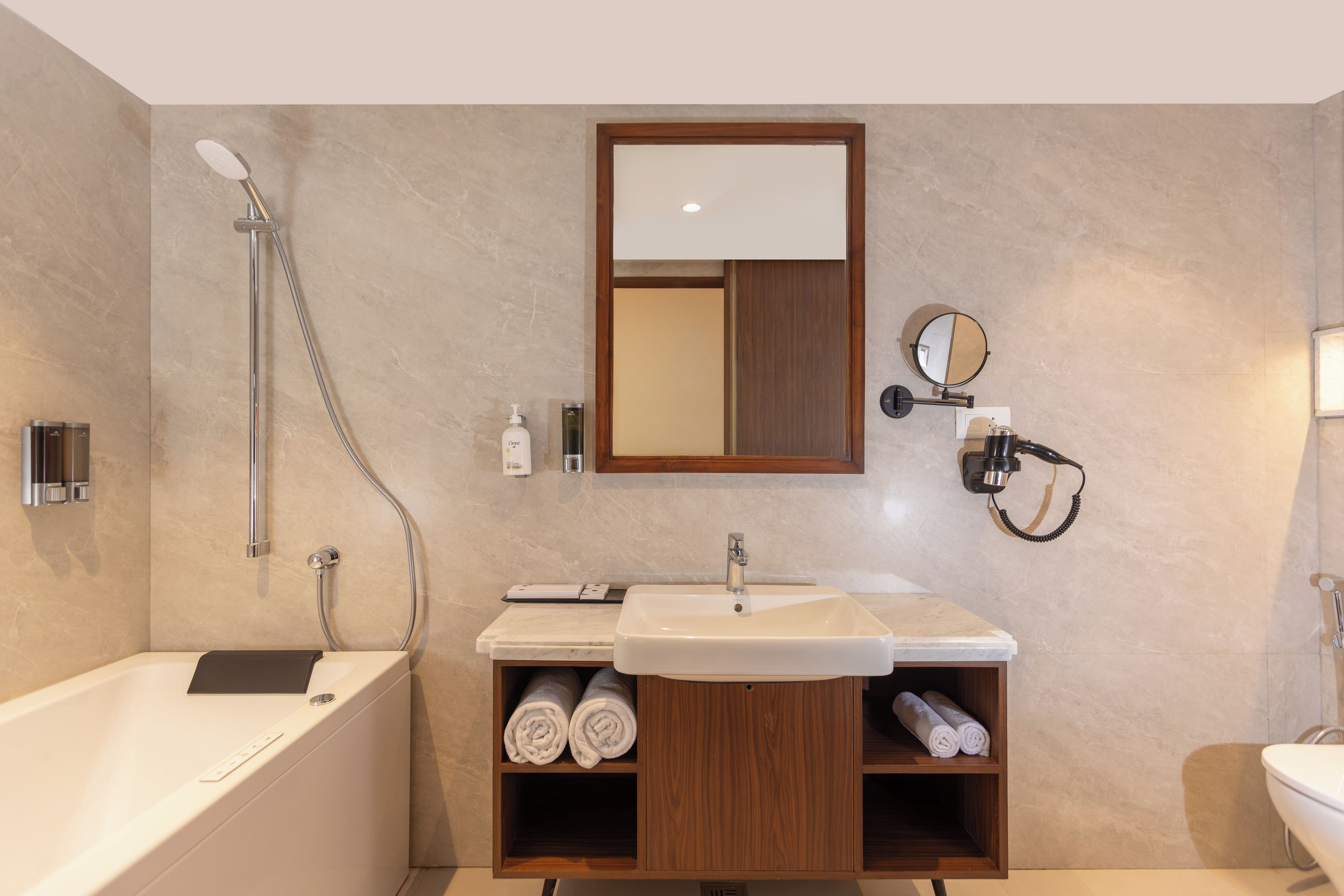 A modern bathroom with a bathtub, a sink, a mirror, and a towel rack.