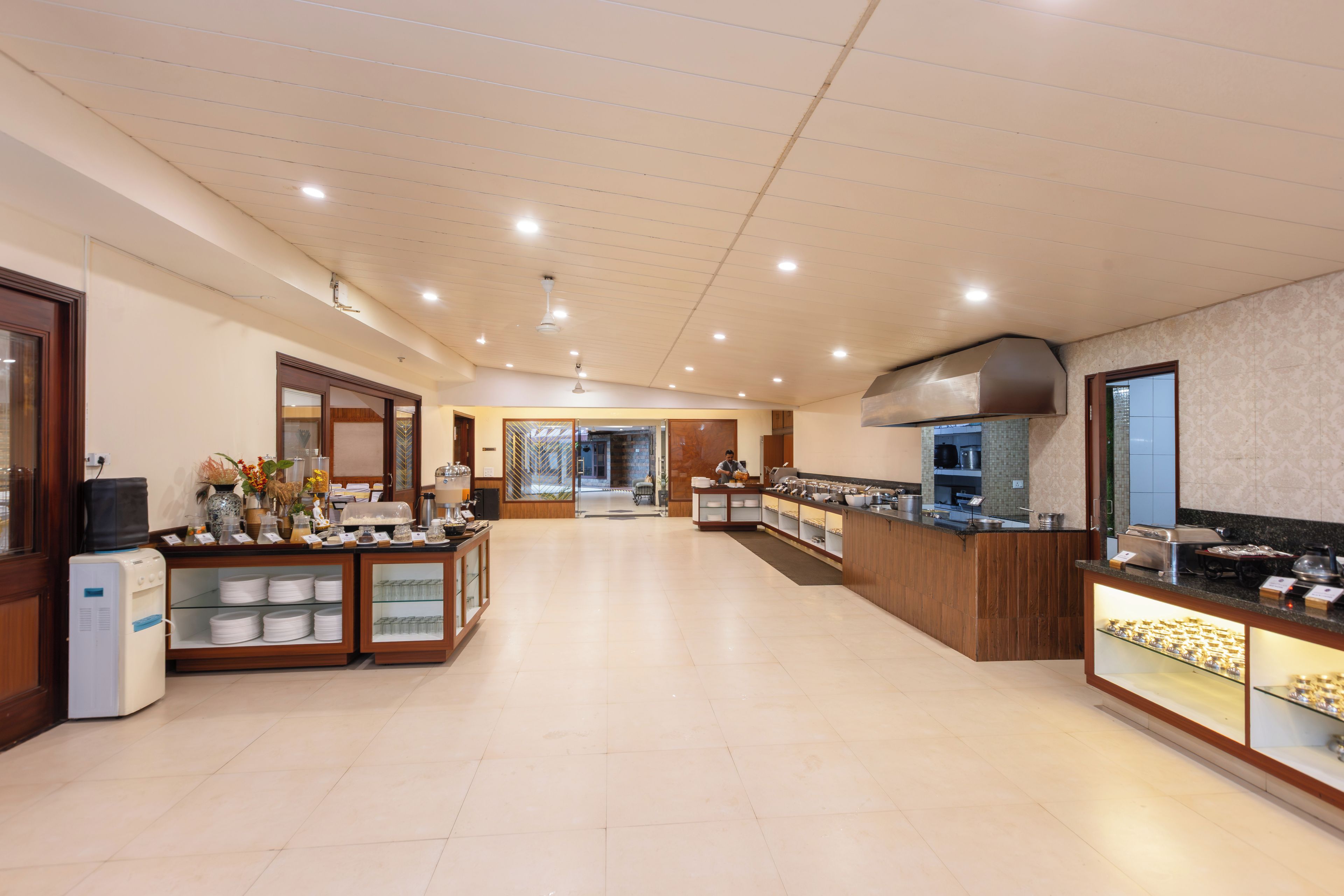 Un amplio vestíbulo de hotel con una recepción, un dispensador de agua y una zona de buffet.
