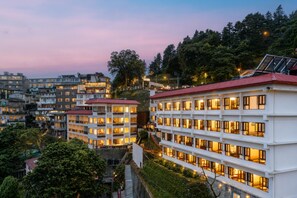 Un hotel de varios pisos con balcones, una escalera y vistas de edificios circundantes.