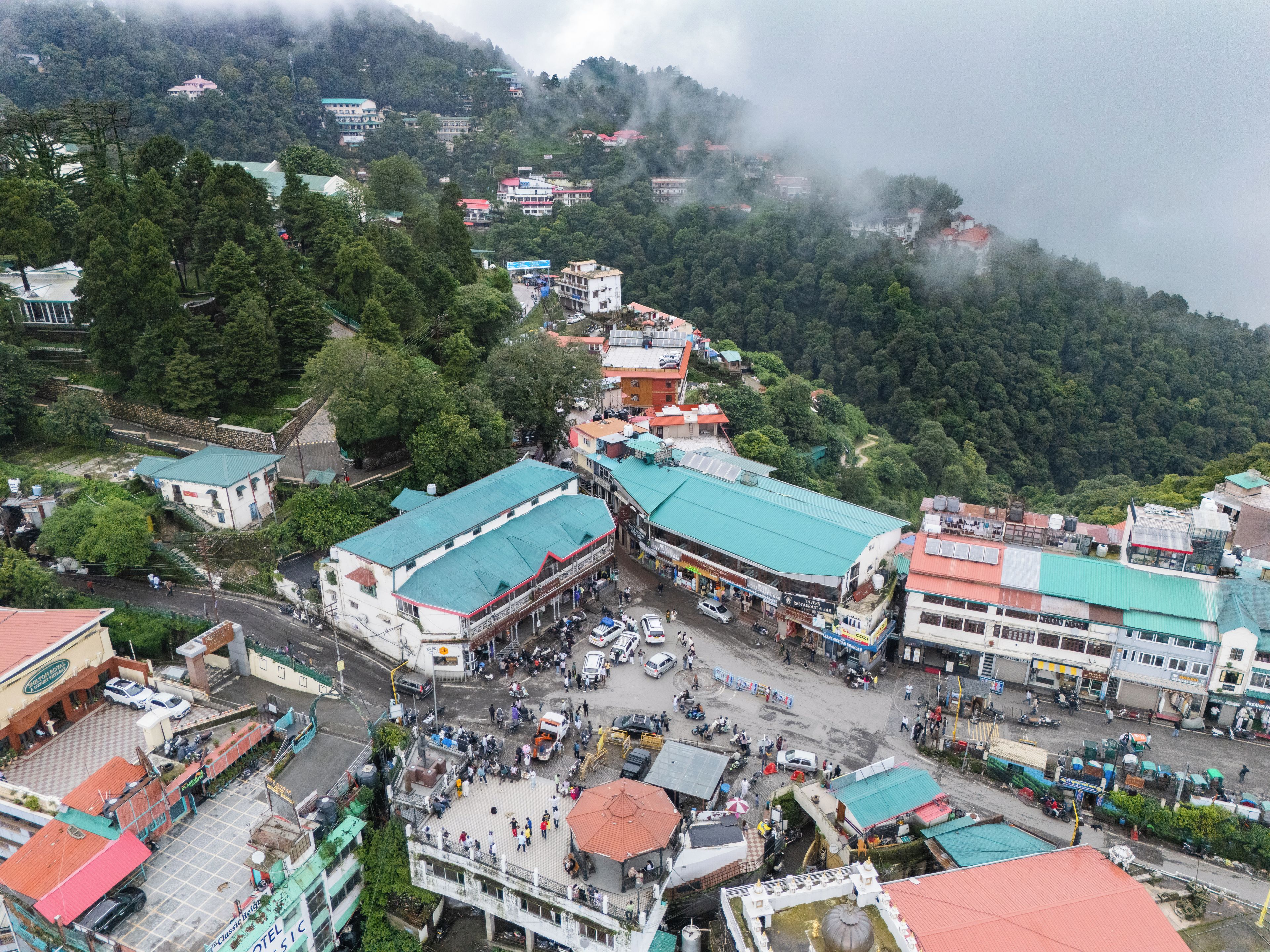 A town with a mix of residential and commercial buildings, a prominent hotel, and a mountainous backdrop.