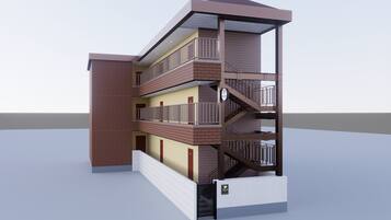 A multi-story building with a brick facade, balconies, and a staircase.