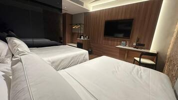 Une chambre d’hôtel avec deux lits, une télévision, un bureau et une chaise.