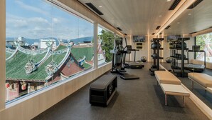 A gym with exercise equipment, benches, and a large window overlooking a traditional building. - Citadines Connect Bertam Georgetown Penang (George Town)