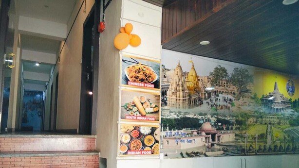 Escadaria que leva a um quarto com um mural de um templo e uma parede com cartazes de comida.