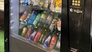 Máquina expendedora con diferentes aperitivos y bebidas, como papas fritas, chocolates y gaseosas.