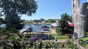 A riverside dock with boats, a statue, and a flag.