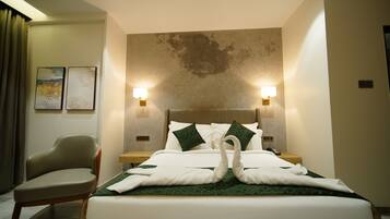 A hotel room with a neatly made bed, two wall-mounted lamps, a chair, and artwork on the wall.