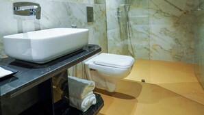 A modern bathroom with a marble sink, a toilet, and a glass-enclosed shower. - Hotel Park Inn Nellore - Near the Hospital & Highway (Nellore)